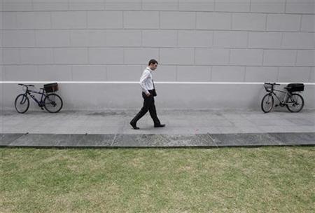 An office worker walks outside a train station during lunch time in Singapore's financial district January 22, 2009. REUTERS/Vivek Prakash